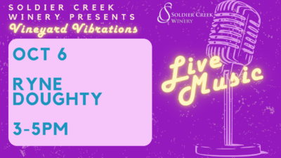 Promotional flyer for Soldier Creek Winery's 'Vineyard Vibrations' event. The flyer features a vintage microphone on the right with glowing text 'Live Music' written in neon-style. The event details are on the left in a blue box, reading: 'OCT 6, Ryne Doughty, 3-5 PM.' The background is a vibrant purple with subtle texture, and the Soldier Creek Winery logo is displayed in the top right corner.