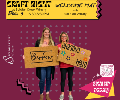 Two women stand holding custom welcome mats they created. One mat says "Berhow" in elegant script, while the other says "Hello" and "Goodbye" with colorful flower decorations. The background is maroon with dotted patterns and geometric accents. The text at the top reads, "Craft Night at Soldier Creek Winery," with details: "Dec. 5, 6:30-8:30 PM." The event features "Welcome Mat with Roo + Loo Artistry." A QR code on the bottom right corner encourages viewers to "Sign Up Today!" Soldier Creek Winery's logo appears on the left.